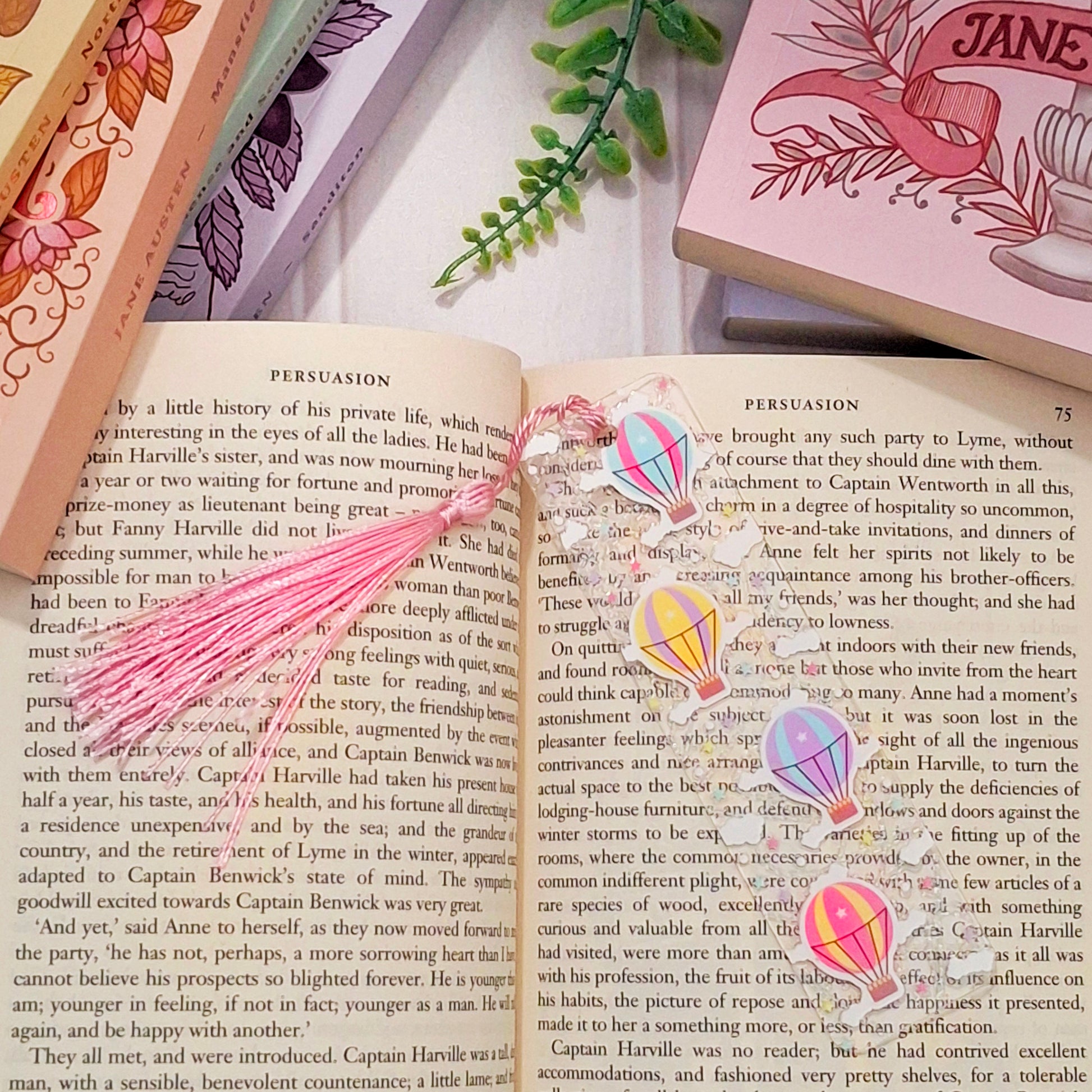Whimsical hot air balloon bookmark with tassel for adventurers, lying across an open book page.