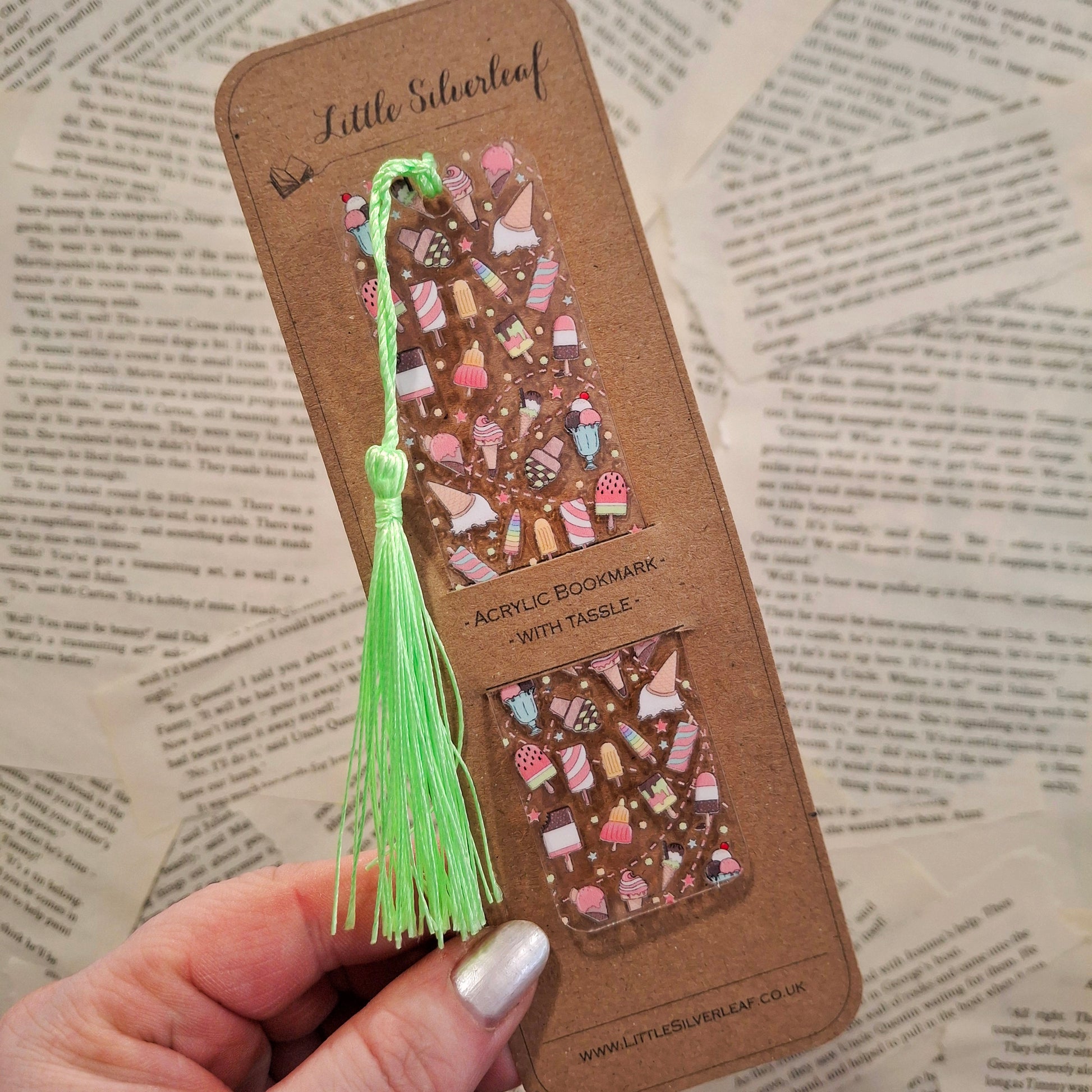Cute dessert bookmark with colourful ice cream illustrations on a kraft brown backing card, held over a book page.