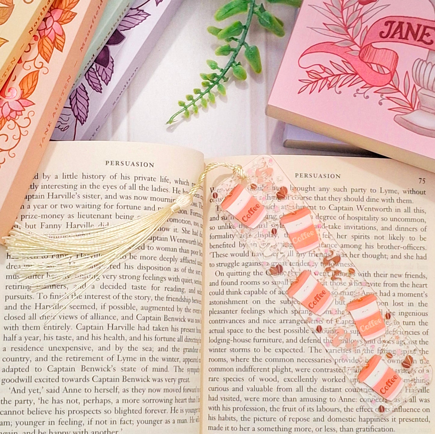 Cosy morning coffee bookmark with tassel for readers, lying across an open book page.