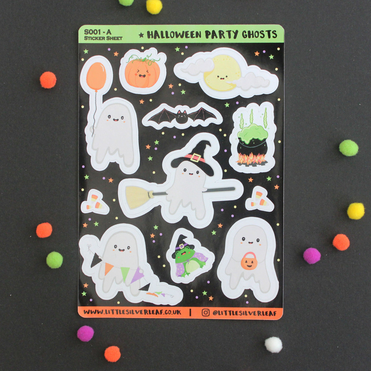 A sheet of cute Halloween party ghost stickers on a black background, surrounded by colorful pom-poms. The stickers feature various smiling ghosts, pumpkins, a bat, and candy corn.