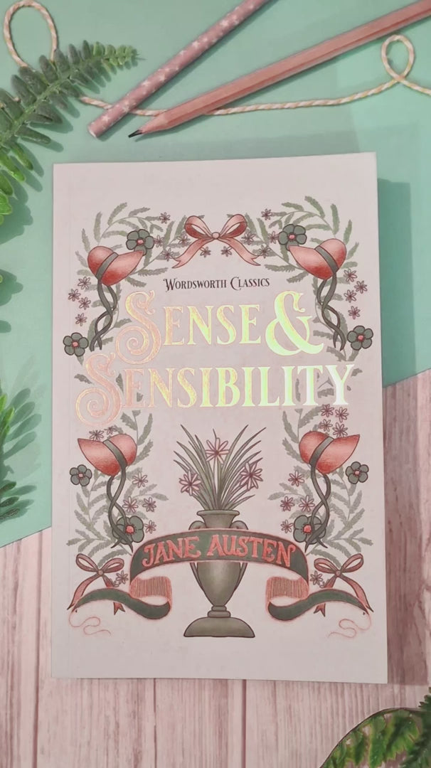 A short video of the Rainbow Bookshelves acrylic bookmark with tassel being taken out of its packaging, shown close to the camera to reveal the detailed rainbow coloured books on shelves  artwork, then used to mark a page in a book.